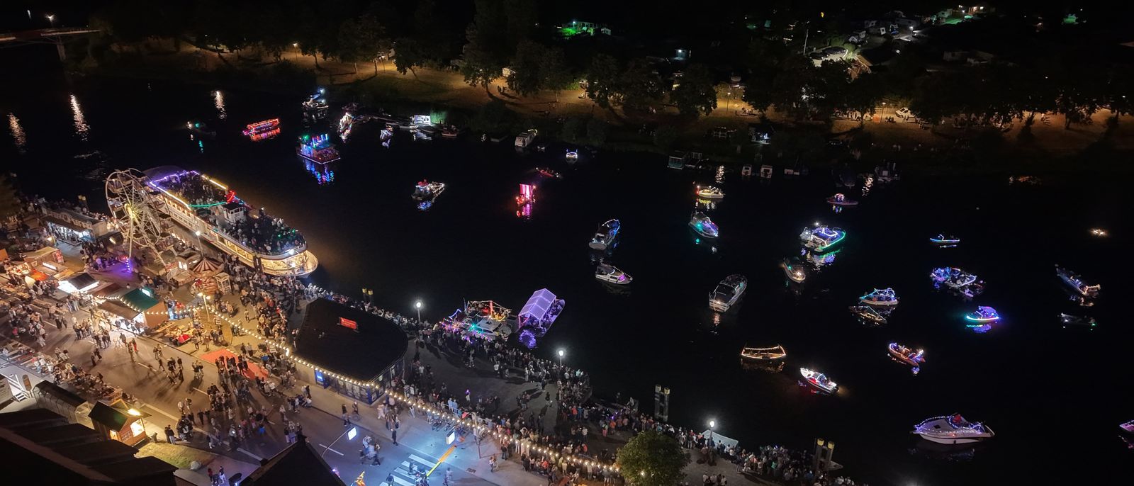 Beleuchtete Boote im Winterhafen und Festmeile am Ufer beim Havelberger Bootskorso