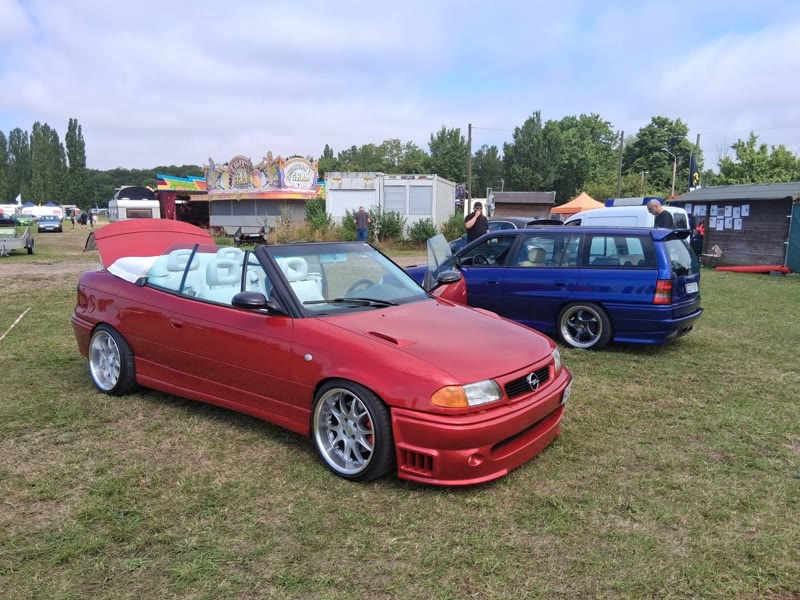 Rotes Cabrio mit weißem Leder, Rummel im Hintergrund