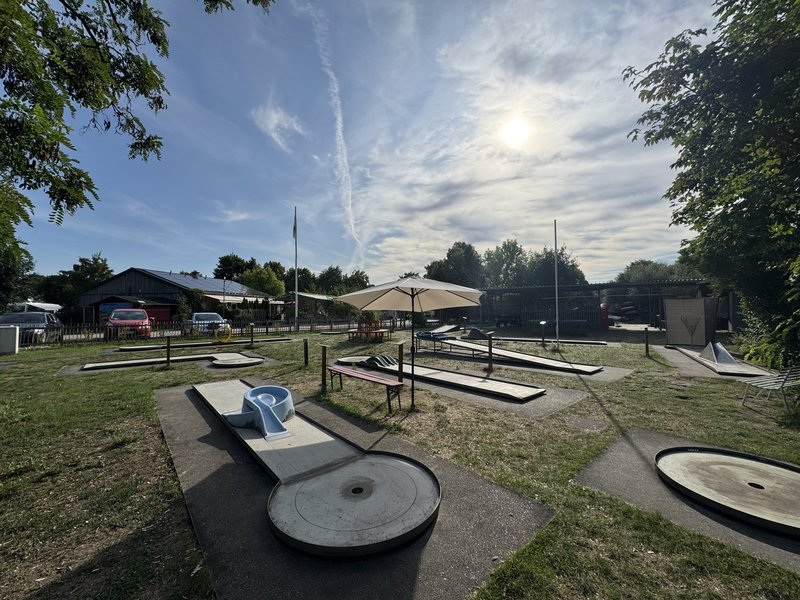 Minigolfanlage Havelberg bei Sonne mit Schirmen und Bänken
