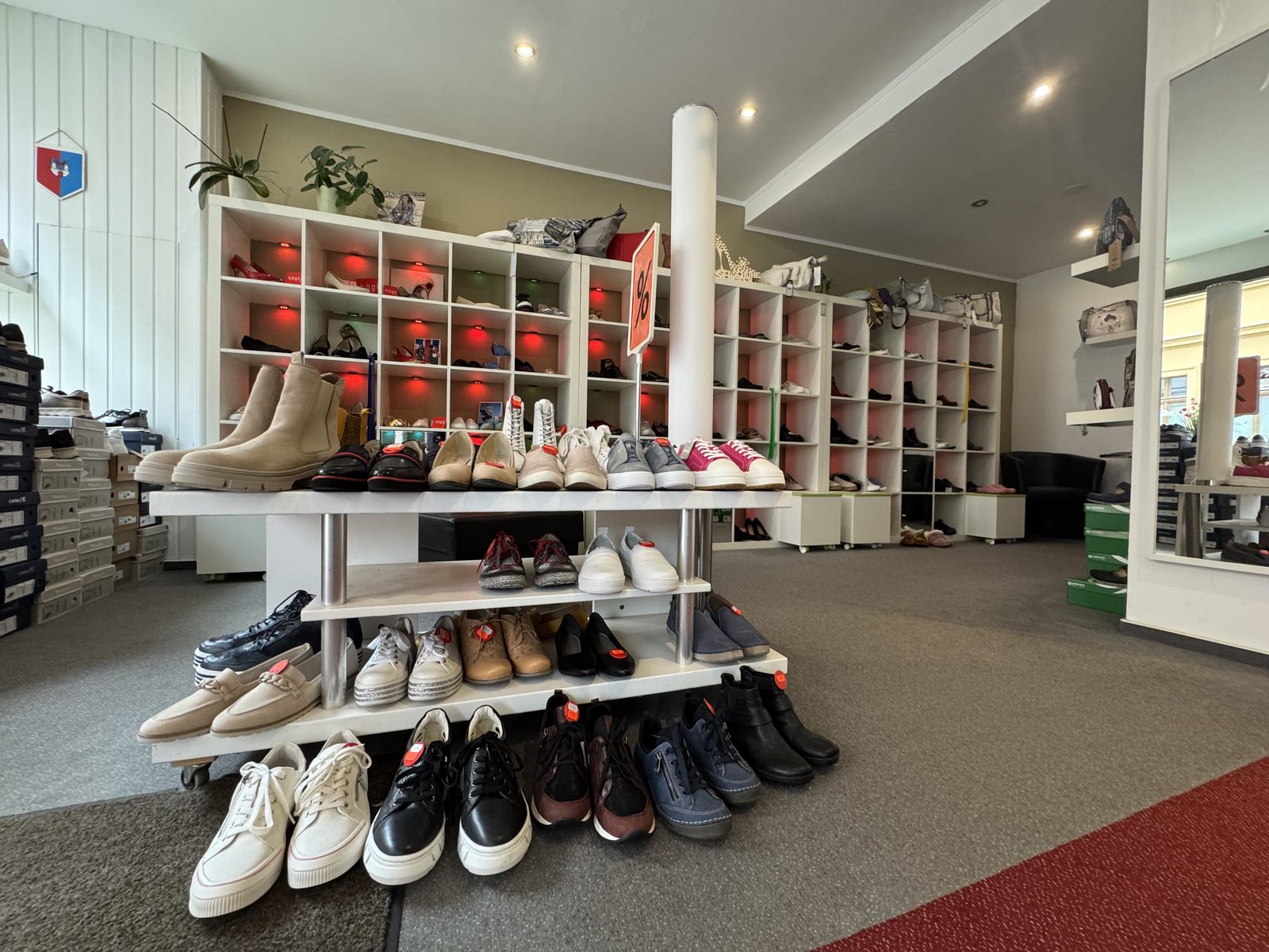 Ladenfläche InselSchuhe mit Angebotstisch und Regalen