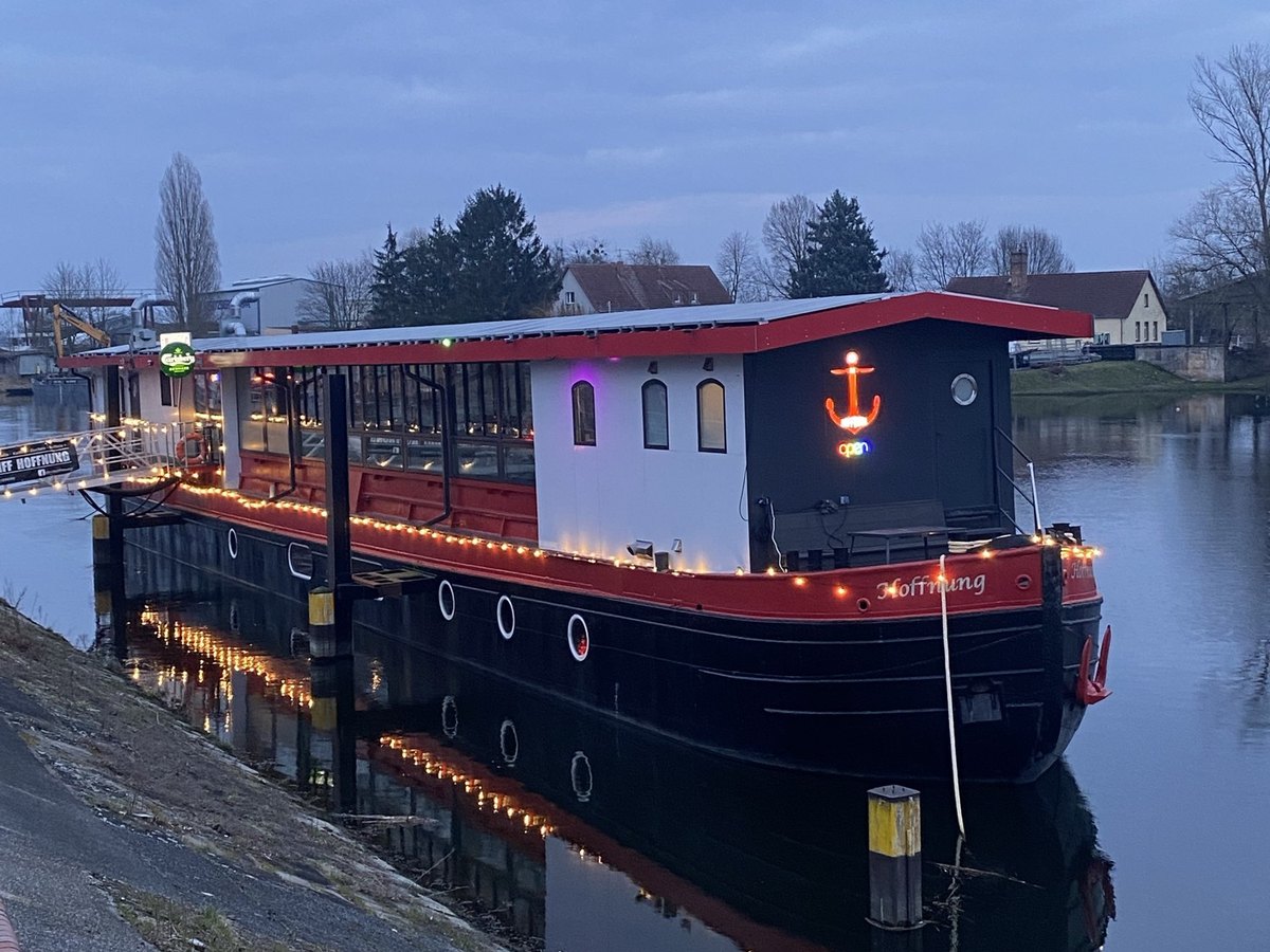 Restaurantschiff Hoffnung am Abend mit Lichterkette und Spiegelung im Wasser