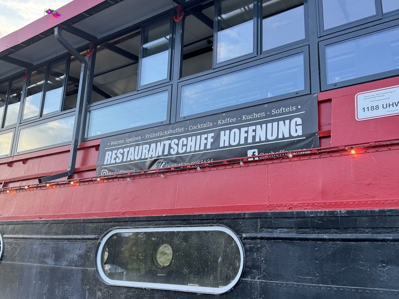 Banner am Restaurantschiff Hoffnung mit Telefonnummer und Angebot