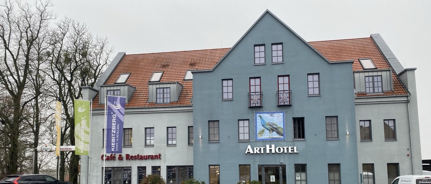 ArtHotel Kiebitzberg in Havelberg: graue Fassade mit ArtHotel-Schriftzug und rotem Ziegeldach am Schönberger Weg