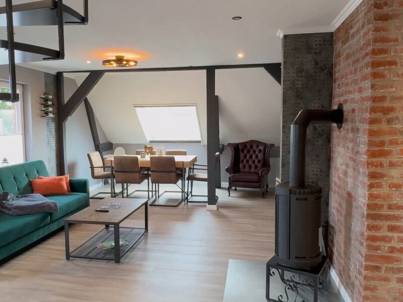 Wohnzimmer mit Esstisch und Kaminofen in Apartment Elbe