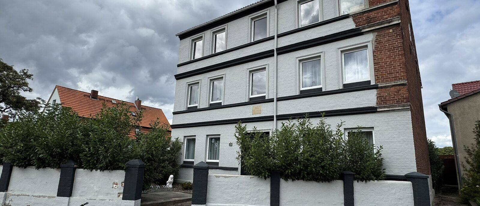 Havelberg Ferien Apartments HCR: weißes Haus Breddiner Straße 4a mit Vorgarten und Fahrrädern