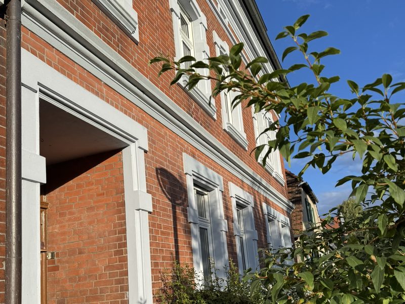Seitenansicht der Pension mit Fußweg und Eingang